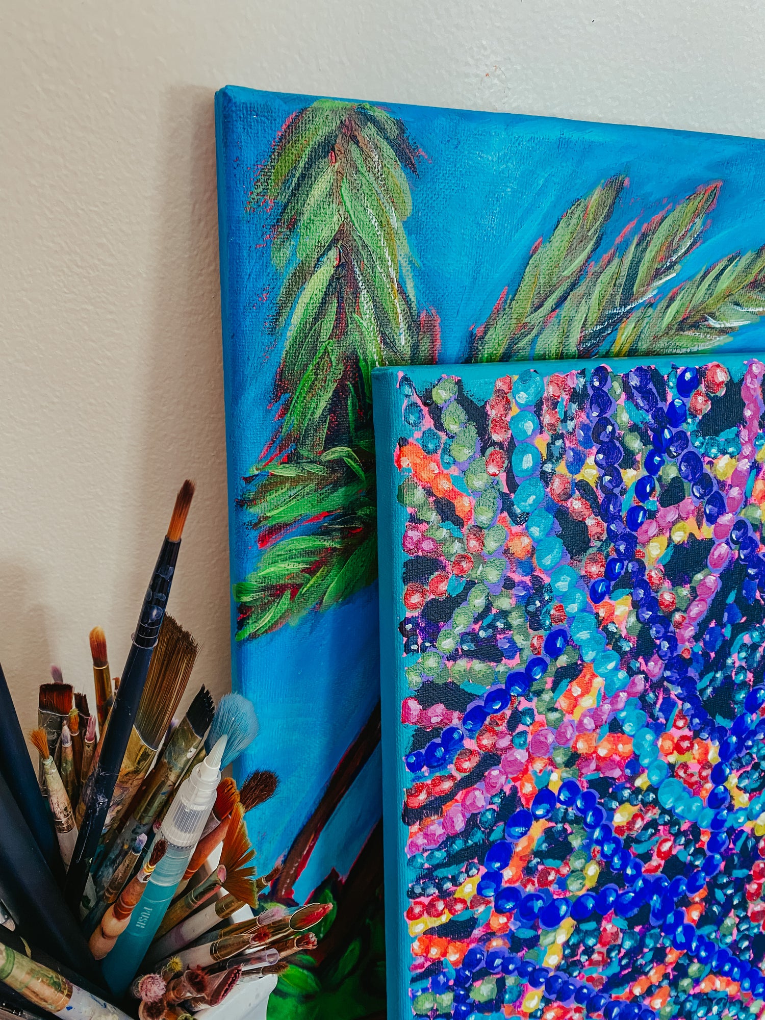 Alexandra Wuyke Art paintings lay against a well.