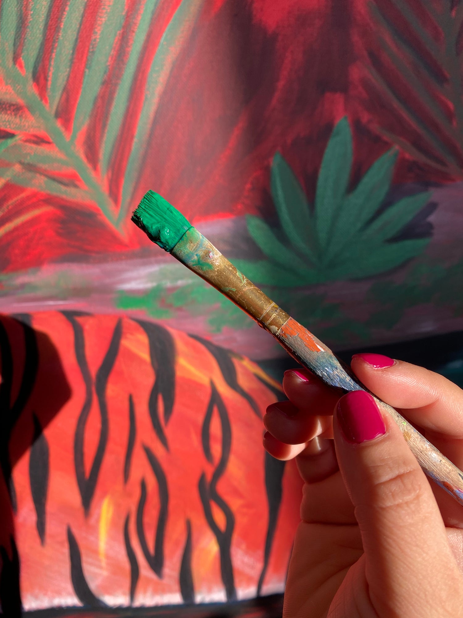 Alexandra Wuyke Art - Alex hold paint brush and works on an original painting.