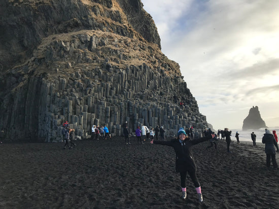 Boston Travel Artist Alexandra Wuyke poses next to a a mountain from one of her travels.